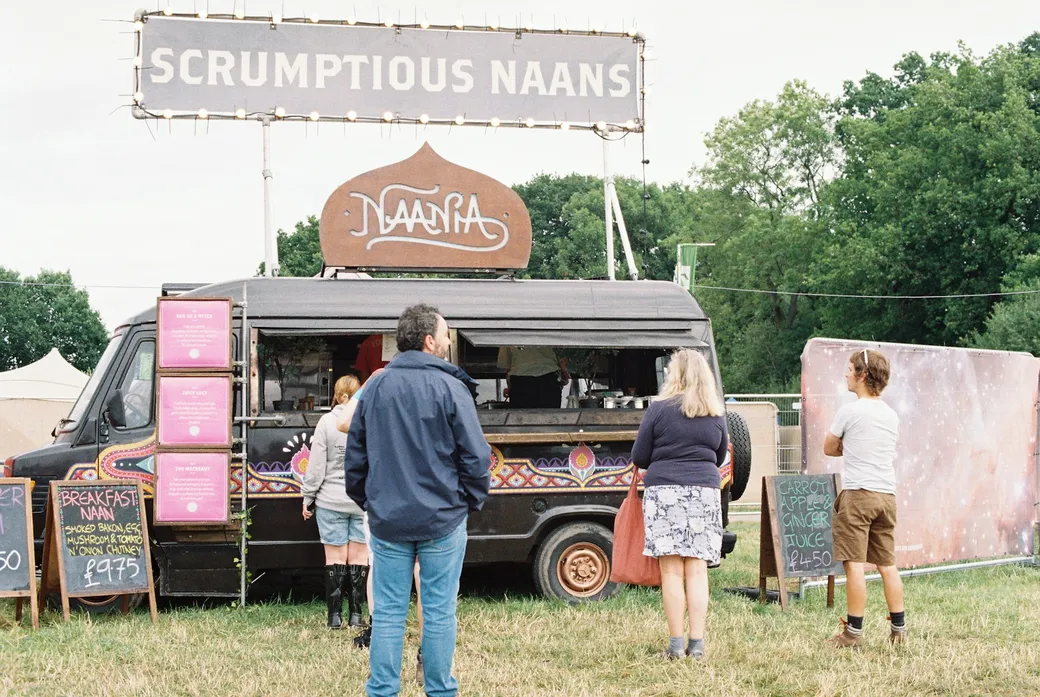 Gäste bestellen an einem Foodtruck auf einem Festivalgelände